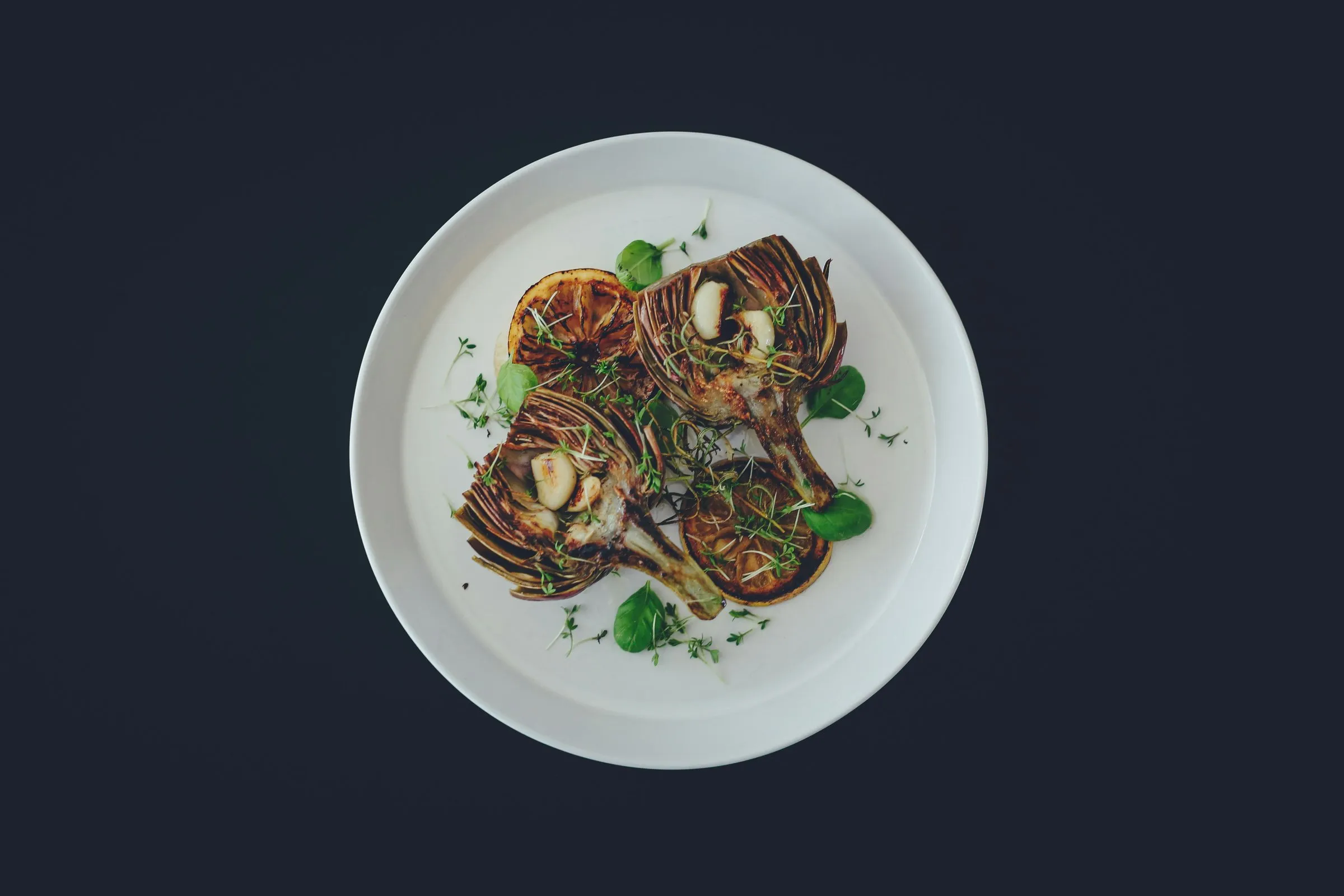 Charred artichoke halves with roasted lemon and garlic