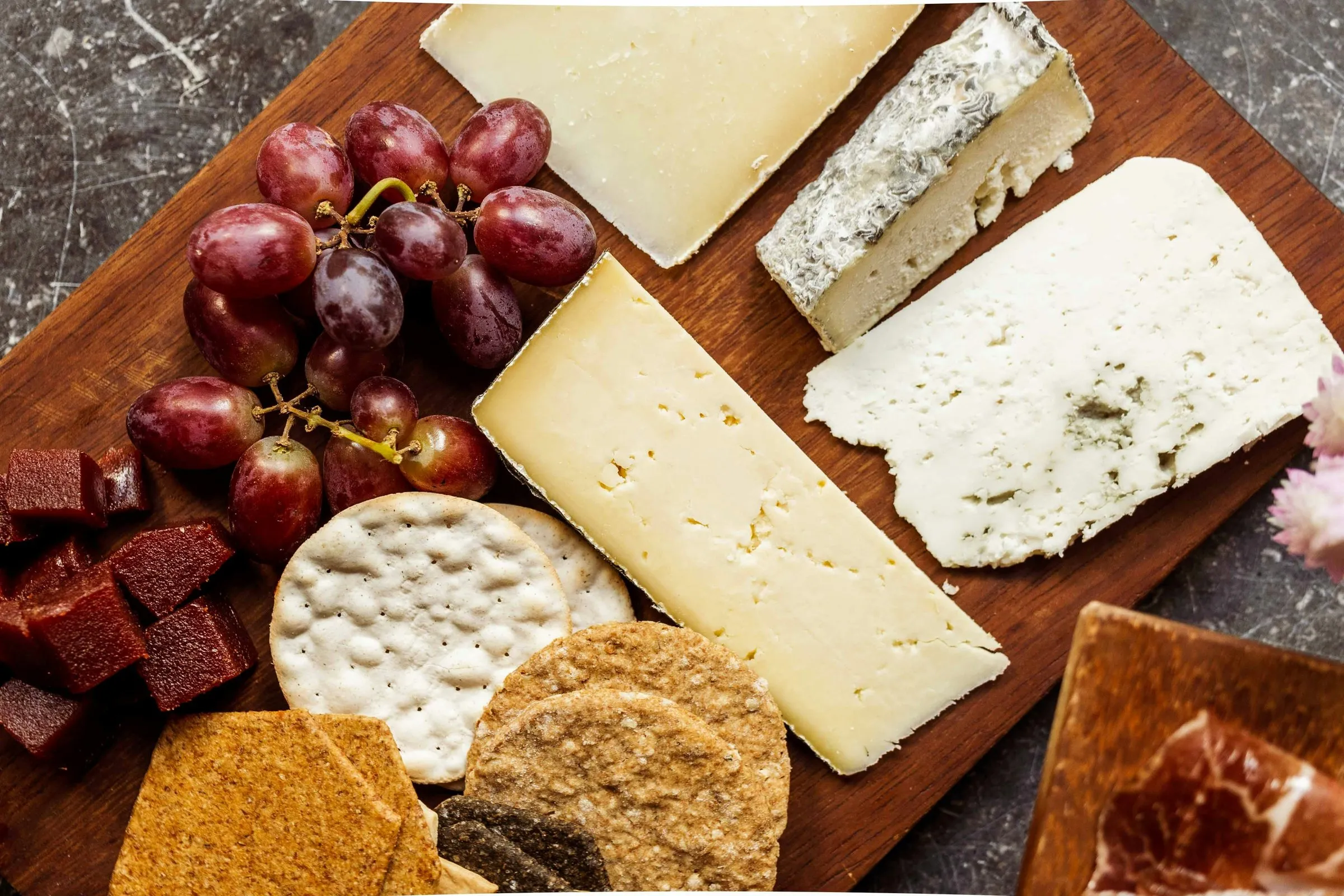 A board of cheeses with bread and fruit