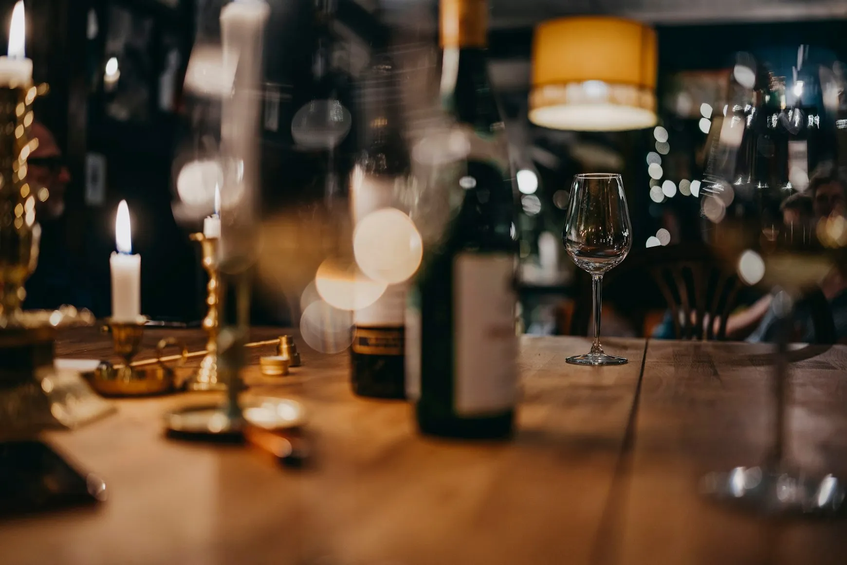 A candlelit wine bar with glasses lined up along the counter